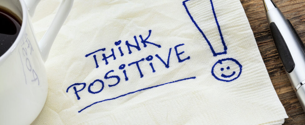 think positive on a napkin think positive - motivational slogan on a napkin with a cup of coffee